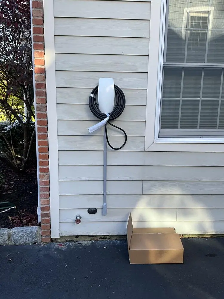 Wall-mounted EV charger on the outside wall of a house
